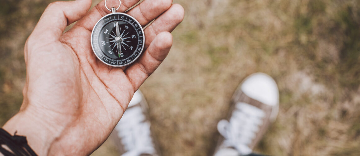 Traveler holding compass in hand